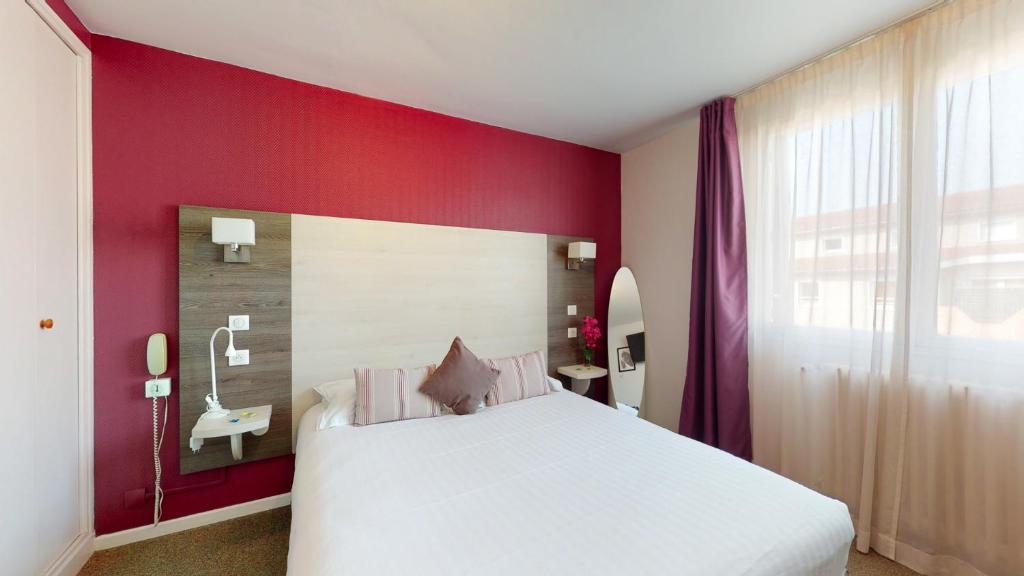 grand lit confortable dans une chambre hôtel Prado à Toulouse